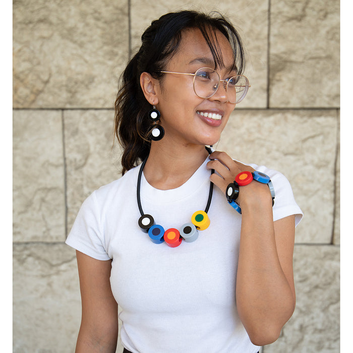 Model waring polka dot bracelet, necklace, and earrings