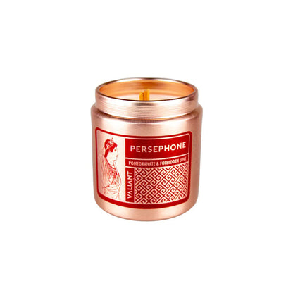 A bronze-colored candle vessel labeled 'PERSEPHONE' with an image of a woman scented with Pomegranate & Forbidden Love