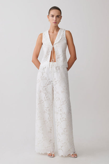 Woman wearing a white broderie tie top with matching pants.